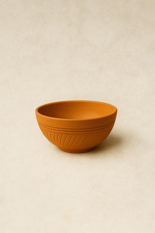 Handmade terracotta bowl with engraved pattern on white background